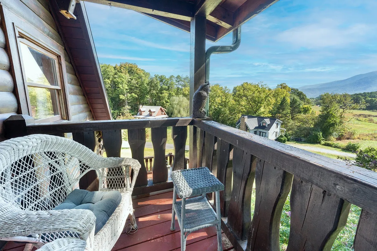 An outdoor seating area with a wicker chair and small side table, offering unobstructed views of the landscape. It’s a tranquil spot for morning coffee or watching the sunrise, highlighting the cabin’s connection to its scenic surroundings.